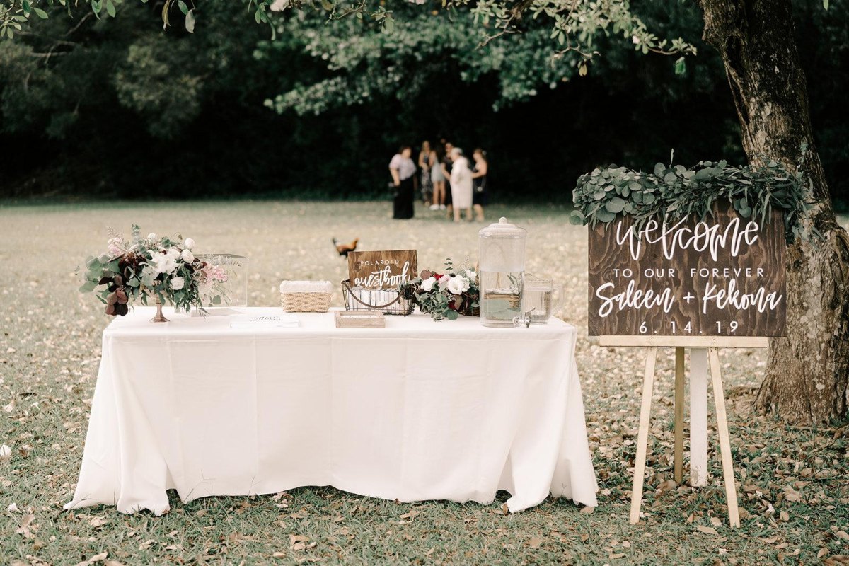 Garden party wedding welcome table greenery