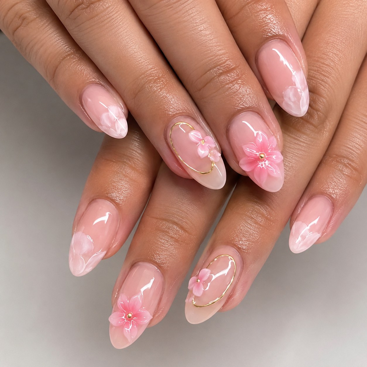 Milky pink short nails featuring delicate 3D flower nail art and gold outlines