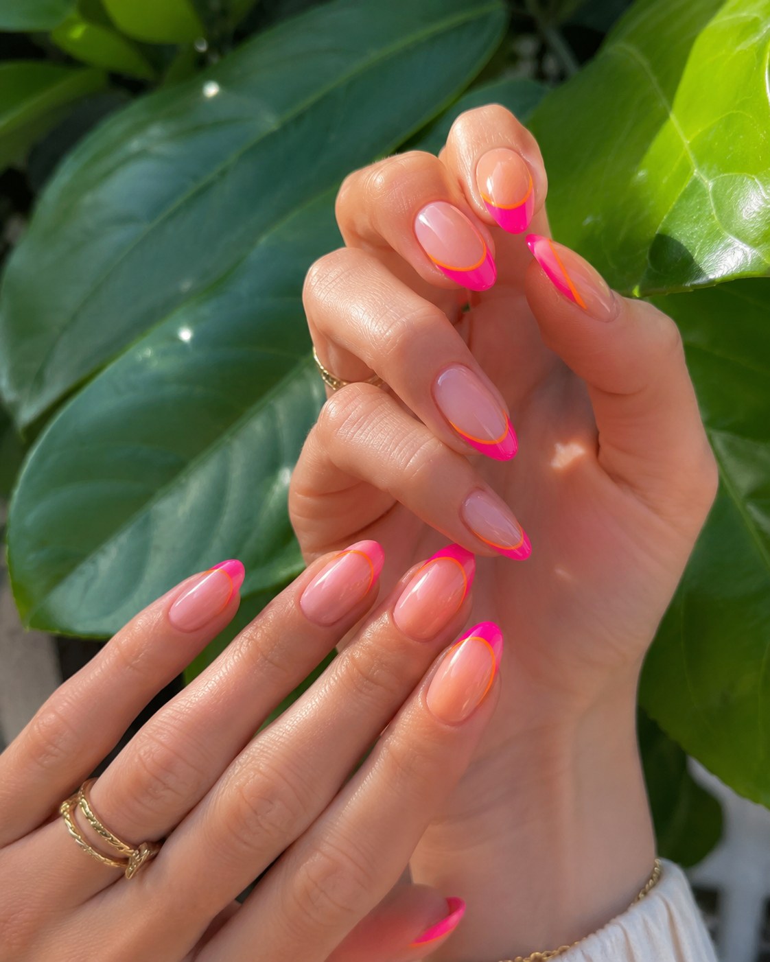 Neon pink French tip short nails over a sheer nude base