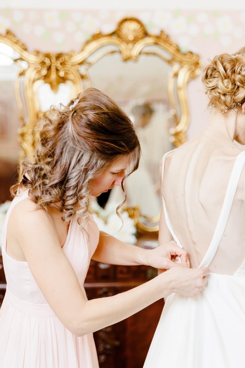 Bridesmaid preparing wedding dress