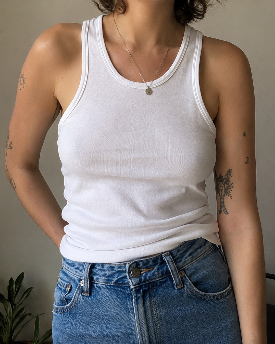 Simple white tank and jeans styled as a minimalist pride outfit idea
