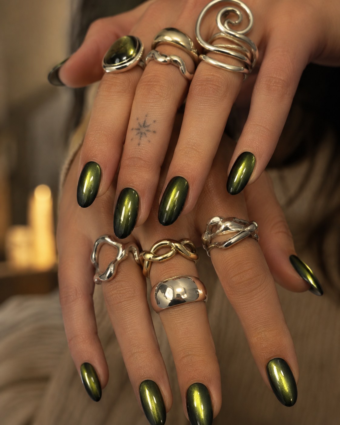Deep emerald chrome cat-eye nails with a magnetic shimmer finish on almond-shaped nails