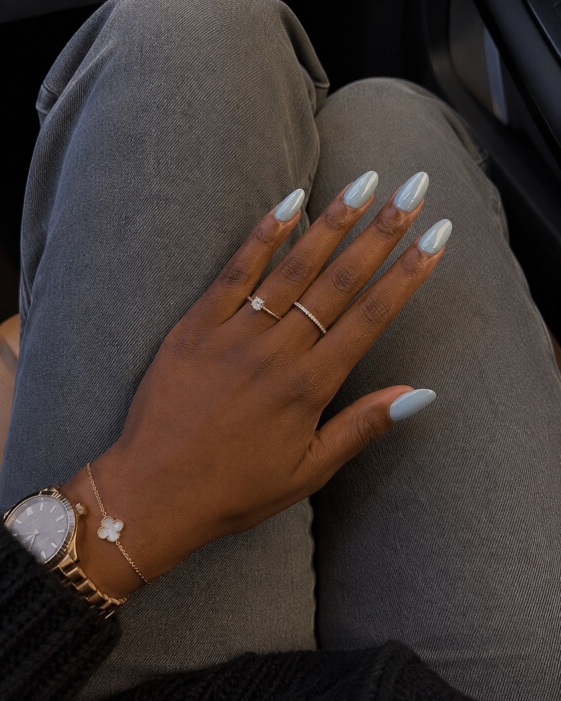 Almond-shaped nails in a solid powder blue, a soft summer nail color for dark skin